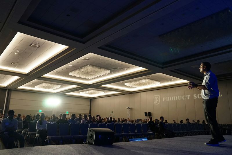 A speaker presenting in a conference hall