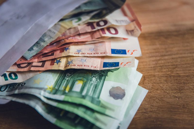 Euro-Banknoten in einem Briefumschlag auf einem Holztisch