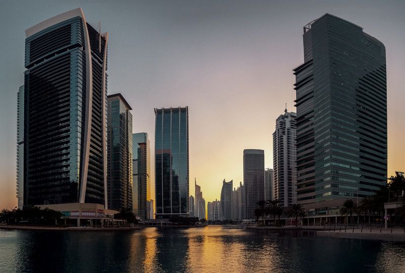 Office towers by a lake in Dubai at sunset