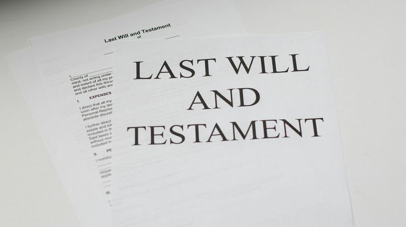 Pages of a Last Will and Testament lying on a white desk